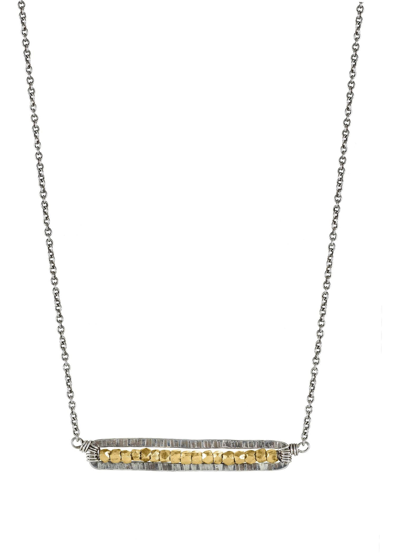 Pod necklace with golden seed beads in a hand-textured, elongated sterling silver frame on a silver chain.