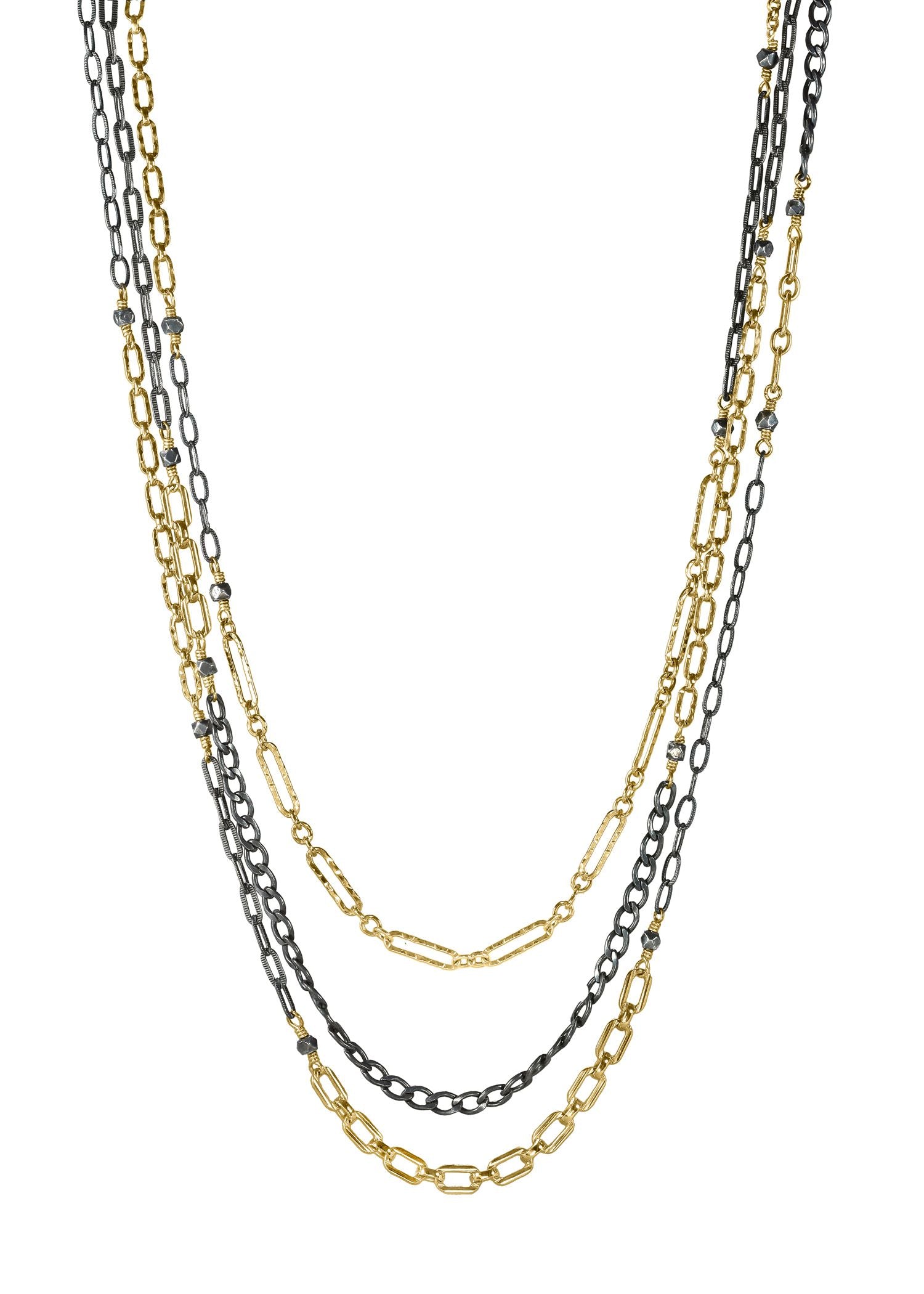 Triple strand necklace in 14k gold fill and blackened sterling silver with faceted silver beads on mixed metal chains.